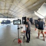 Sebastian Nieves films with the veterans group in a hangar with a vintage Huey.